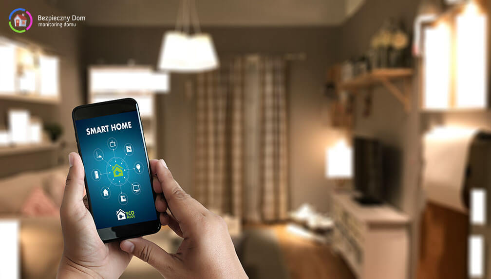 Telefon komórkowy z aplikacją smartfon trzymany w męskich dłoniach na tle przytulnego pokoju