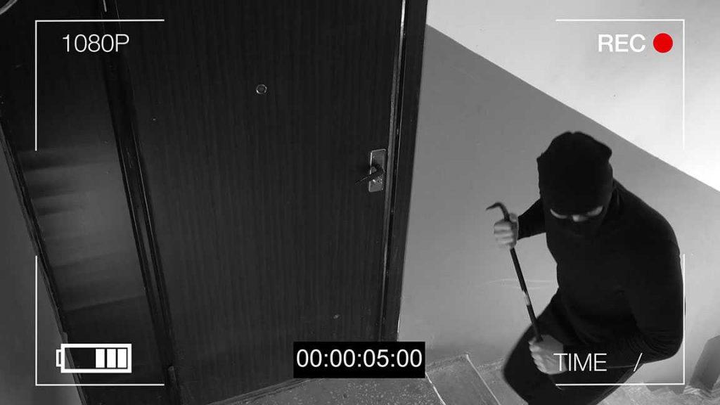 Widok z kamery złodzieja z łomem stojącego pod drzwiami